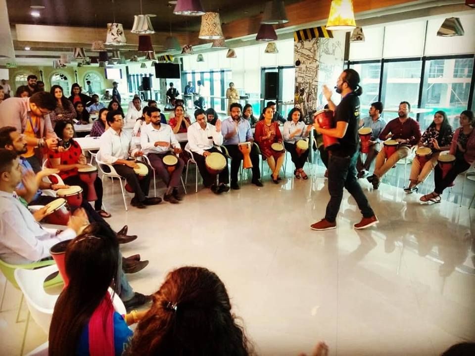 Corporate drum-circle workshop in a bright event hall