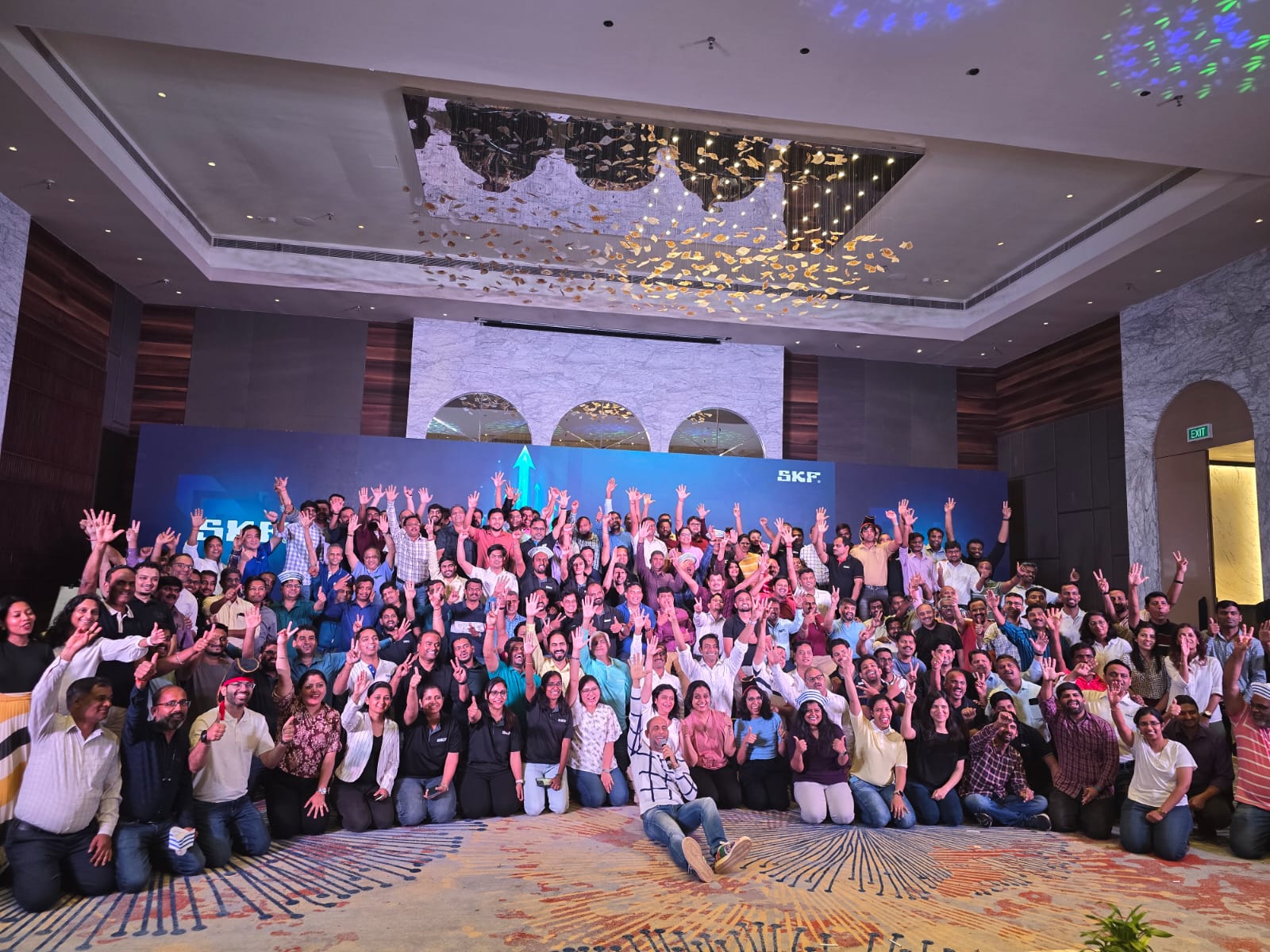 Large team group photo in a premium event hall